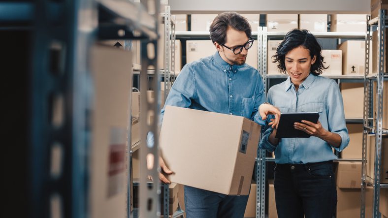 warehouse workers talking looking at tablet