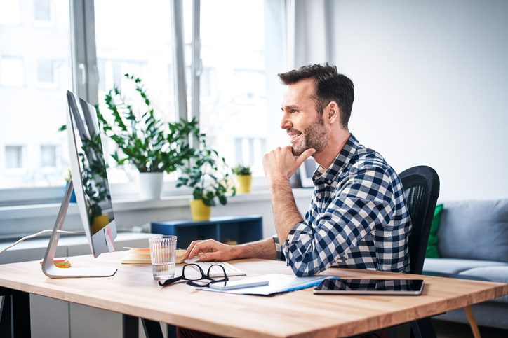 man working on computer at his desk 