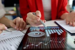 Business women studying charts and diagrams on digital tablet closeup. 