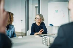 Confident female professional discussing in board room. Senior businesswoman planning with team in a meeting.