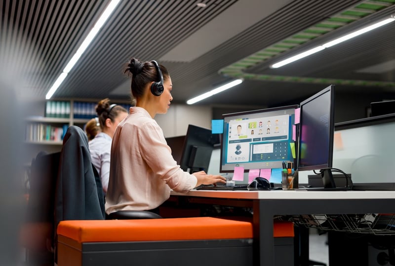 woman working at her desk wearing headset