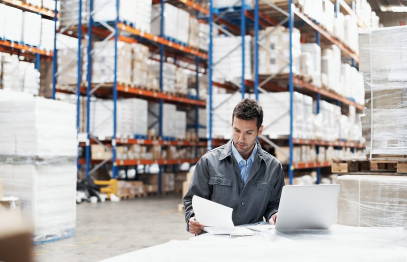 man looking at warehouse paperwork