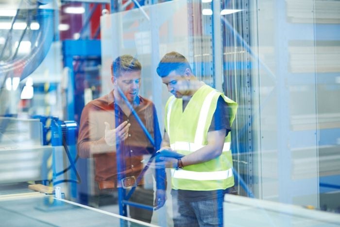 Two colleagues on factory shopfloor using digital tablet