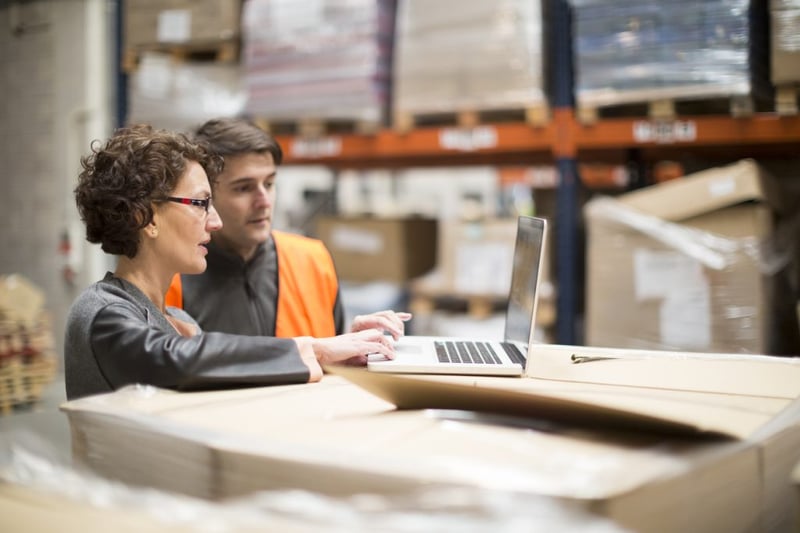 warehouse managers looking on laptop