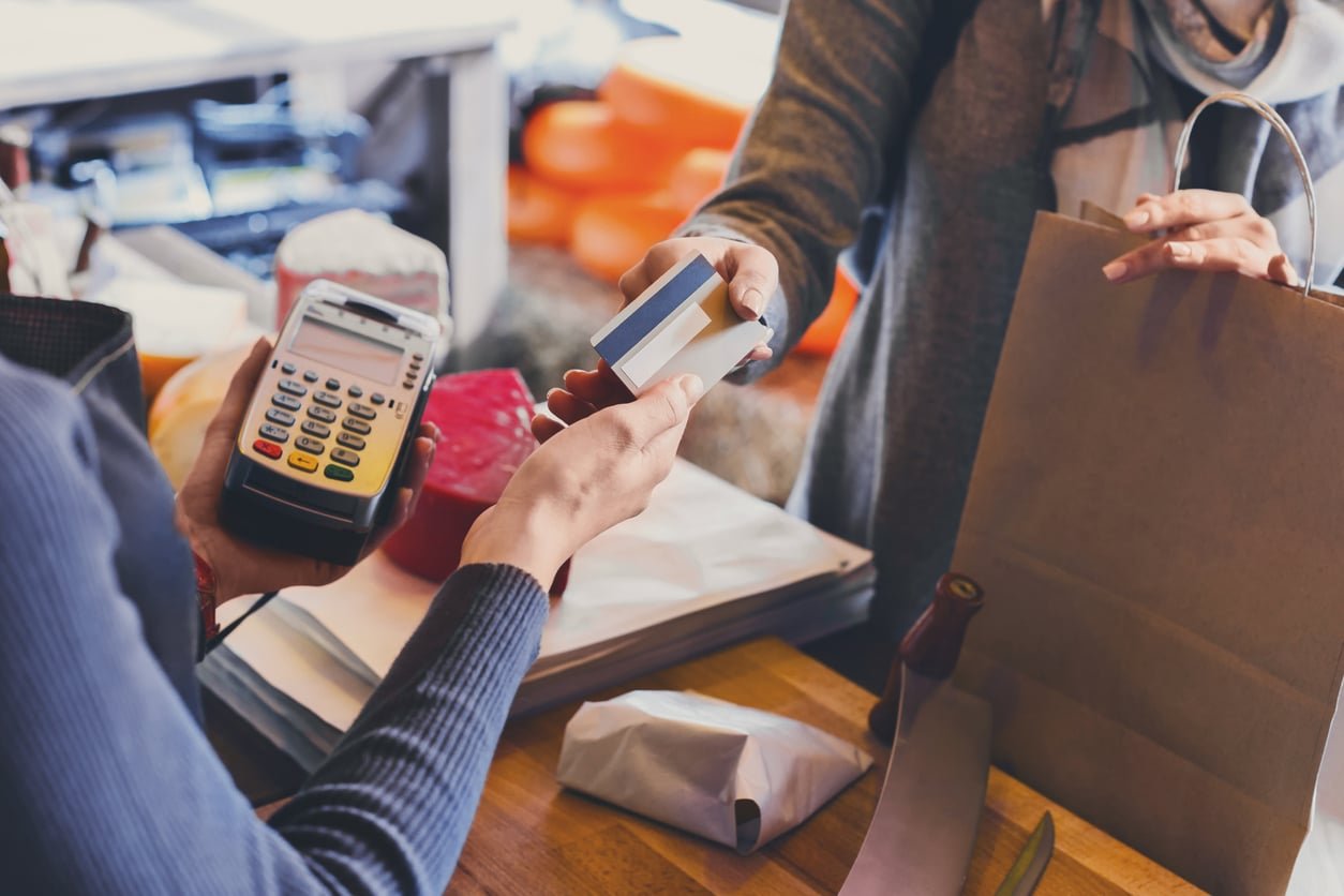 Retail, credit card payment service. Customer paying for order of cheese in grocery shop.