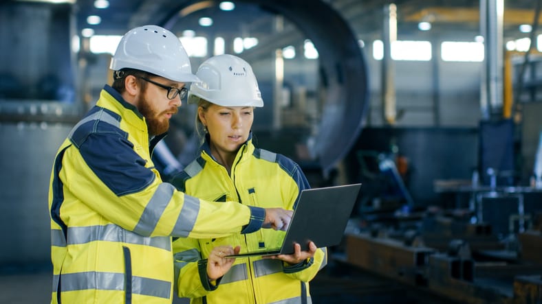 engineers looking at laptop discussing plans